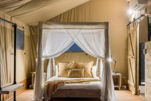 巴利纳Ballina Beach Nature Resort的一间卧室配有一张天蓬床和窗户