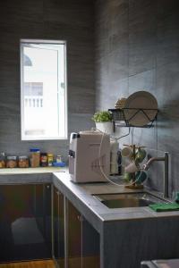 麻坡Amoris Grand Event Space的厨房柜台设有水槽和微波炉