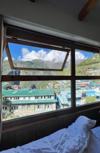 NamcheHotel Camp de Base的卧室设有窗户,享有大楼的景致。