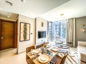 迪拜STAY BY LATINEM Luxury 1BR Holiday Home CV A2604 near Burj Khalifa的客厅配有餐桌和沙发
