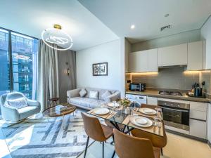 迪拜STAY BY LATINEM Luxury 1BR Holiday Home CV A2604 near Burj Khalifa的厨房以及带桌椅的起居室。