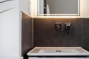 瓦尔内明德LIGHTHOUSE APPARTEMENTS的一间带水槽和镜子的浴室