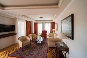 雅典雅典伊莱克特拉宫的客厅配有沙发、椅子和电视
