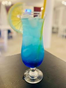 PonoarelePerla Muntilor Ponoarele, Padurea de liliac的坐在桌子上的玻璃杯里喝的蓝色饮料