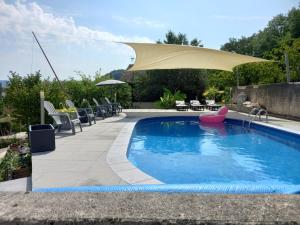 MontmorotChalet cocooning pleine nature的一个带太阳伞和椅子的游泳池