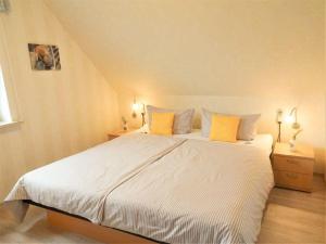 佩尔沃姆Hus-Pellworm-2-Ferienwohnung-Meereswelle的卧室配有一张带黄色枕头的大型白色床。