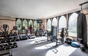 伯明翰New Hall Hotel & Spa, Birmingham的健身房有跑步机和举重器材,有一名女性背景