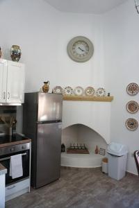 帕拉代西翁Amalia's Traditional Home in Paradisi的厨房配有冰箱和墙上的时钟