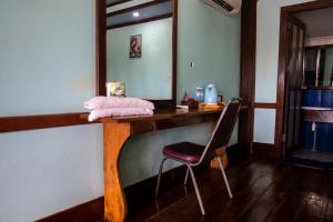 Ban KhonNongsak Riverside Guesthouse & Nongsak Guesthouse的一张带椅子和镜子的木桌