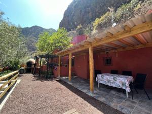 因赫尼奥Casa Rural Guayadeque Ca'Juani的一座带桌子和山的房屋的庭院