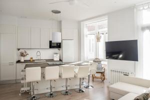 维戈Casa MIMOSA Vigo的厨房配有白色橱柜和桌椅