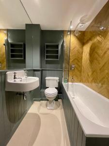 索尔兹伯里奎德汉姆普顿磨坊公寓的浴室配有卫生间、盥洗盆和浴缸。
