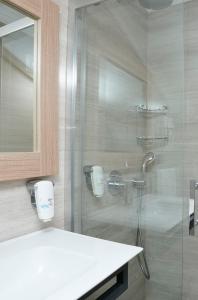 费特希耶Alesta Seaside Residence的带淋浴、盥洗盆和镜子的浴室