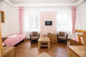 卡尔洛瓦斯图丹卡Hotel Džbán的一间设有两张床和一张桌子及椅子的房间
