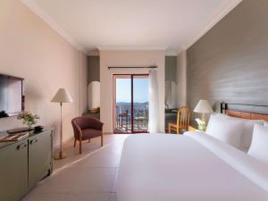 瓦迪穆萨Grand Mercure Petra的酒店客房设有一张大床和一个阳台。