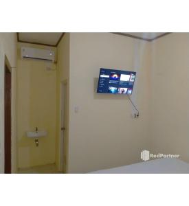 北加浪岸Navisha Guest House Syariah near Exit Tol Batang RedPartner的一间位于客房墙上的带电视的浴室