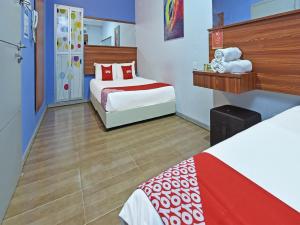 瓜拉丁加奴Super OYO 768 Fajar Baru Boutique Hotel的酒店客房带两张床,红色和白色