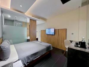 雅加达Erian Hotel的卧室配有一张床,墙上配有电视。