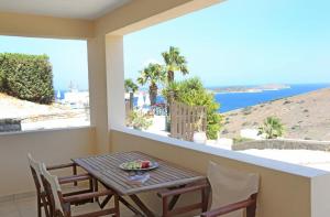 阿佐里姆诺斯日出海滩套房酒店的阳台配有桌椅,享有海景。