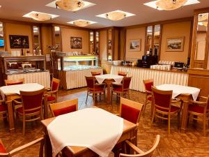 布拉格阿斯卡尼亚酒店的一间带桌椅和柜台的餐厅