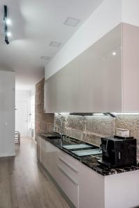 维戈Casa MIMOSA Vigo的厨房配有白色橱柜和黑色台面
