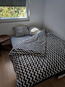 瓦列沃Nina的一张带黑白色棉被的床和窗户