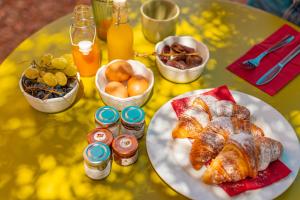 切法卢Villa Totò Resort的一张桌子,上面放着一盘羊角面包和其他早餐食品