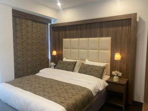 阿尔梅勒Hotel Cataleya的一间卧室配有一张大床和木制床头板