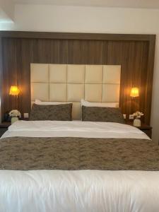 阿尔梅勒Hotel Cataleya的卧室内的一张大白色床,配有两盏灯