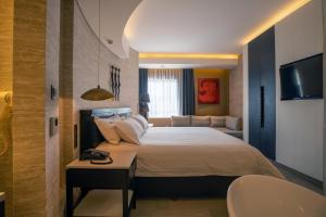 内罗毕Tribe Hotel, Nairobi, a Member of Design Hotels的一间卧室配有一张大床和一张沙发