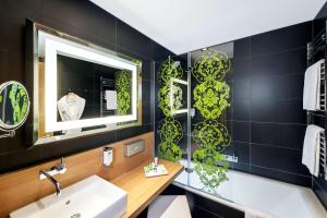 美因河畔法兰克福NH法兰克福展会酒店的一间带水槽和镜子的浴室