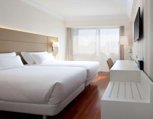 潘普洛纳NH潘普洛纳伊鲁纳公园酒店的酒店客房设有一张白色大床和一个窗户。