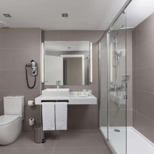 潘普洛纳NH潘普洛纳伊鲁纳公园酒店的浴室配有卫生间、盥洗盆和淋浴。