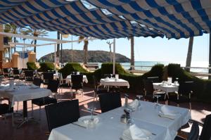 马萨龙港Hotel Playa Grande的一间设有白色桌椅的海洋餐厅