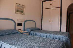 马萨龙港Hotel Playa Grande的酒店客房设有两张床和一个衣柜。