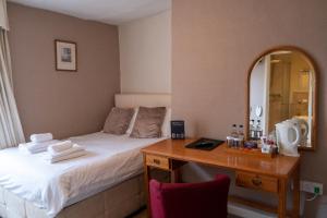 阿伯加文尼金斯海德酒店的客房设有一张床和一张带镜子的书桌