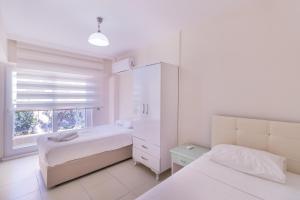 马尔马里斯Apartments Near to City Center and Beach的一间白色卧室,配有两张床和窗户