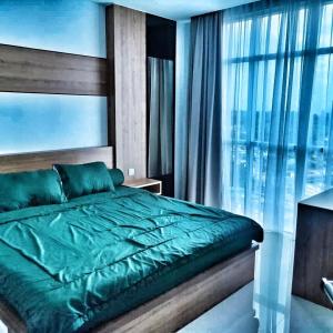 名古屋Sleptopia@ formosa residence APARTMENT 70M2 W/ best interior & view in town的一间卧室设有一张绿色的床和一个大窗户