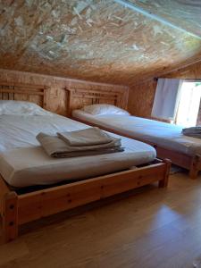 帕特里莫尼奥Casa di legnu ,charmant chalet avec piscine的配有木天花板的客房内的两张床