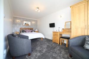 凯西克Dalegarth Guesthouse Portinscale的一间卧室配有一张床、一张桌子和两把椅子