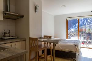 Refugio Lo ValdésLodge El Morado的厨房配有桌子和山景窗户。