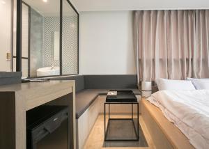 仁川市Hotel Wolmido的一间卧室配有一张床、一张桌子和一个水槽
