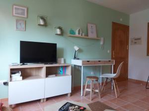 塞埃APARTAMENTO ESTORDE - COSTA DA MORTE的客厅配有电视、书桌和椅子