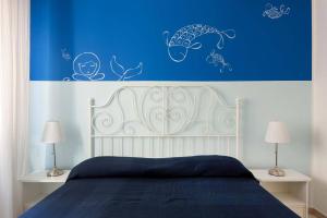 贾迪尼-纳克索斯Il Fascino della Sirena - Sea House的一间卧室设有蓝色墙壁、一张床和两盏灯。