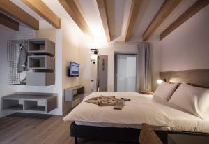 阿科Casa Alla Lega的一间卧室配有一张带白色床单和木制天花板的大床。