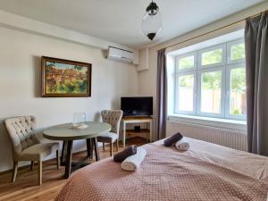 布拉格Apartmán Praha Břevnov的一间卧室配有一张床、一张桌子和一个窗户。