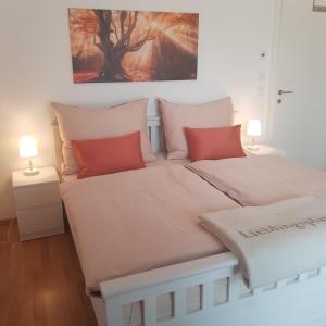 塞博登Hepp-Lounge的一间卧室配有两张带红色枕头的床