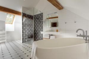 布拉格Hotel At the White Lily的白色的浴室设有浴缸和淋浴。