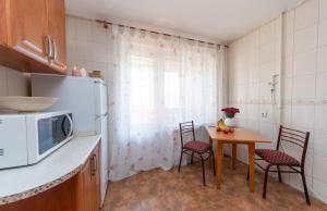 基辅Затишна квартира в центрі Оболоні м Київ的厨房配有桌椅和微波炉。