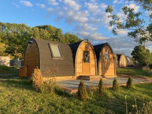 LeightonRabbit Glamping Pod School House Farm的田野中间的小木屋